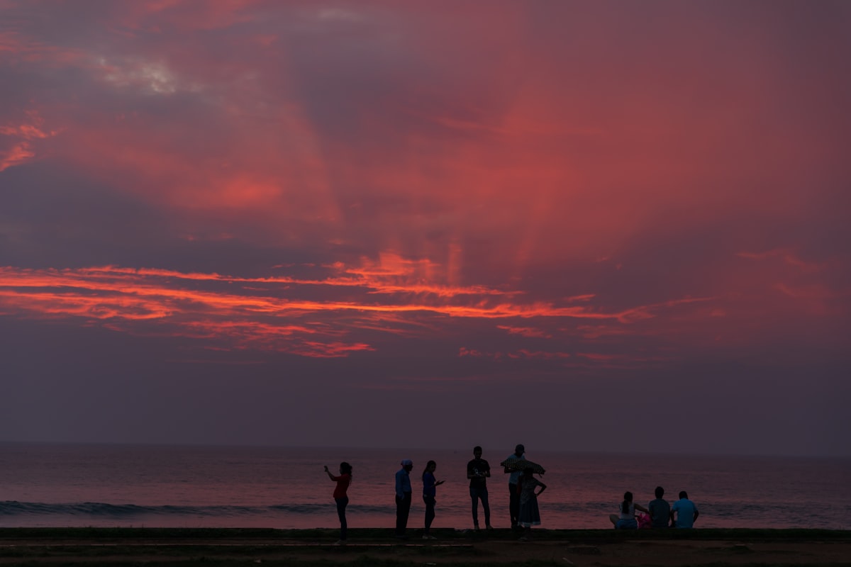 Dramatic crimson sunset with silhouettes of people on Galle Fort ramparts